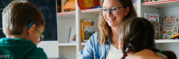 Mitarbeiterin spielt mit zwei Kindern